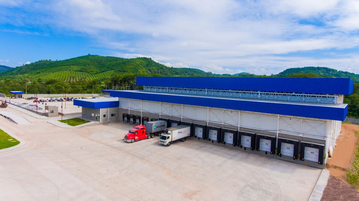 Vista aérea de la planta de Guangolola Logistics: nave de almacenamiento en frío, andenes de carga con camiones y patio de maniobras.
